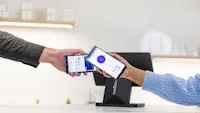 Customer paying with smartphone at point of sale terminal.